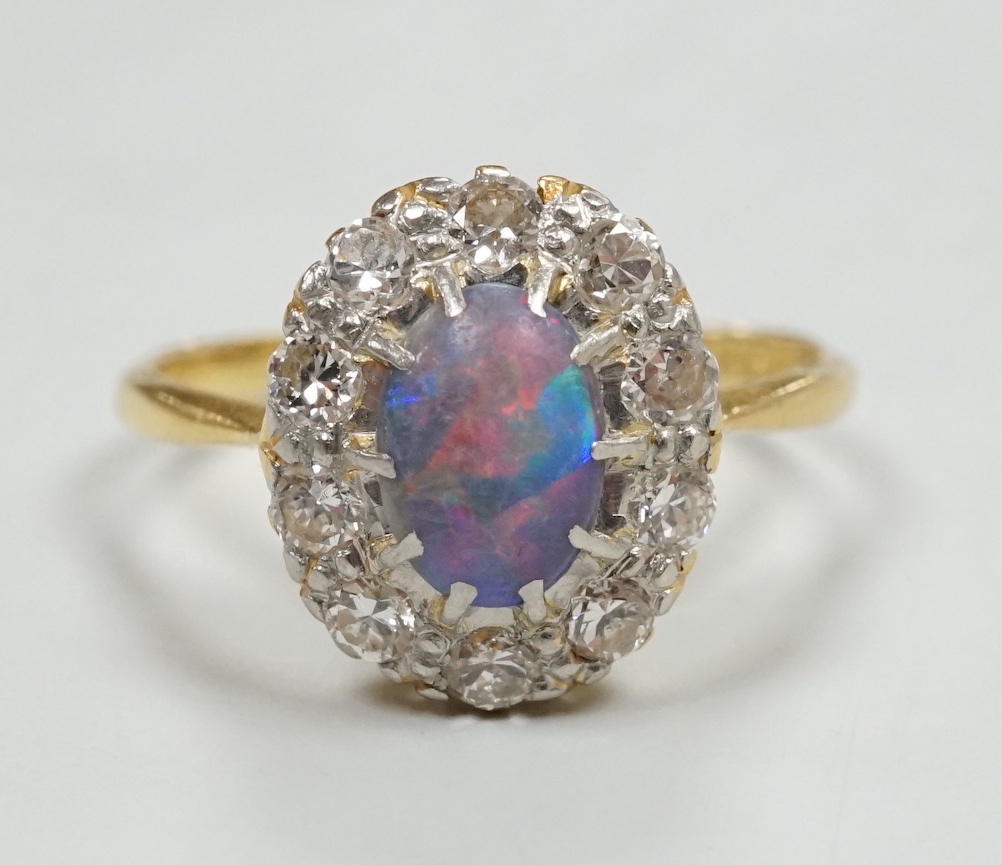 An early 20th century 18ct, black opal and diamond set oval cluster ring, size O, gross weight 2.8 grams.